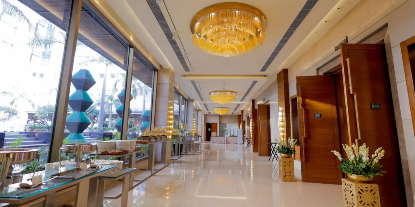 The chandelier-lit pre-function corridor at Crowne Plaza, Gurgaon